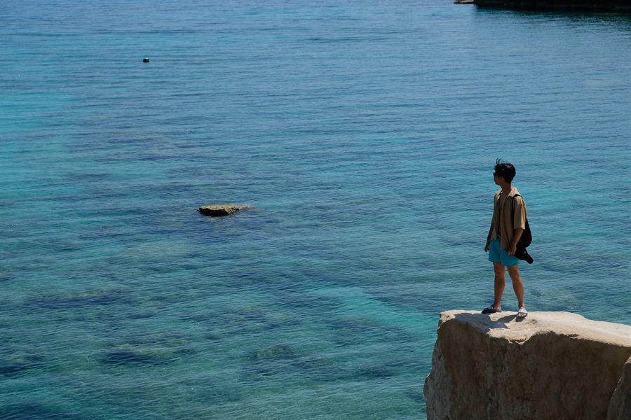 Standing on a cliff over turquoise water